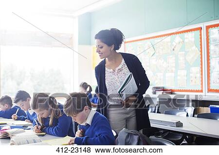Female teacher with her pupils in classroom View Large Photo Image Stock Photo - Female teacher with her pupils in classroom. Fotosearch