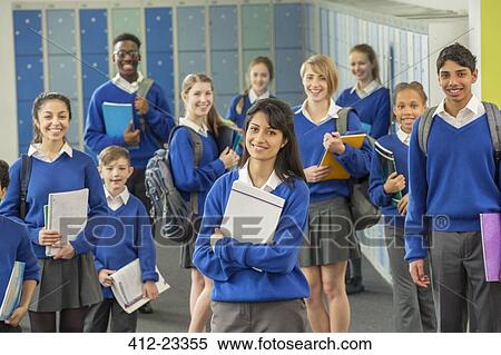 Stock Photography - Group portrait of schoolchildren wearing school uniforms standing in corridor and smiling. Fotosearch