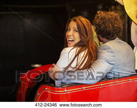 Man embracing scared girlfriend while going into tunnel in ghost train View Large Photo Image Stock Photograph - Man embracing scared girlfriend while going into tunnel in ghost train. Fotosearch
