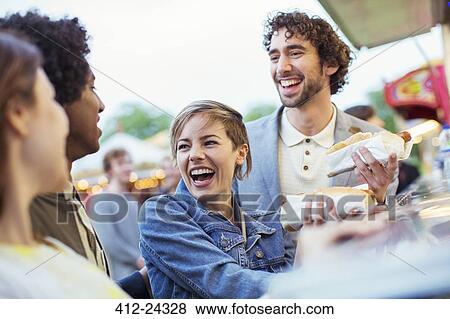 People buying hot dogs in food stand in amusement park View Large Photo Image Stock Photo - People buying hot dogs in food stand in amusement park. Fotosearch