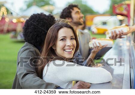 People buying hot dogs in food stand in amusement park View Large Photo Image Stock Photo - People buying hot dogs in food stand in amusement park. Fotosearch