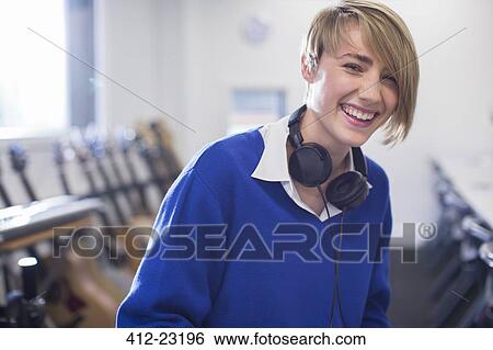 Portrait of female student with headphones in classroom View Large Photo Image Stock Photograph - Portrait of female student with headphones in classroom. Fotosearch