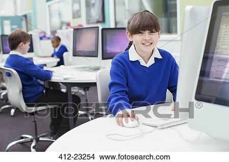 Portrait of primary school girl wearing blue school uniform using computer View Large Photo Image Picture - Portrait of primary school girl wearing blue school uniform using computer. Fotosearch