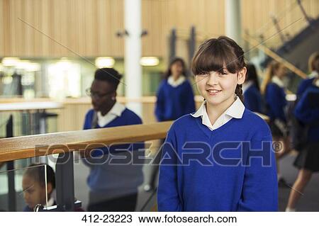 Portrait of smiling elementary school girl wearing blue school uniform standing in school corridor View Large Photo Image Stock Image - Portrait of smiling elementary school girl wearing blue school uniform standing in school corridor. Fotosearch