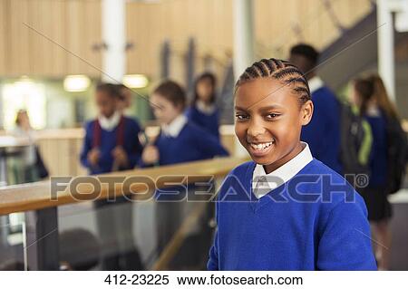Stock Photography - Portrait of smiling elementary school girl wearing blue school uniform standing in school corridor. Fotosearch