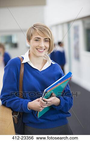 Portrait of smiling female student wearing school uniform standing in corridor View Large Photo Image Stock Photograph - Portrait of smiling female student wearing school uniform standing in corridor. Fotosearch