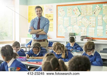 Stock Photography - Portrait of smiling teacher and elementary school children in classroom. Fotosearch