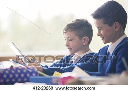 Primary school boys with digital tablets in classroom View Large Photo Image Stock Photo - Primary school boys with digital tablets in classroom. Fotosearch