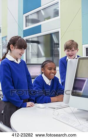 Primary school children looking at computer and smiling View Large Photo Image Stock Image - Primary school children looking at computer and smiling. Fotosearch
