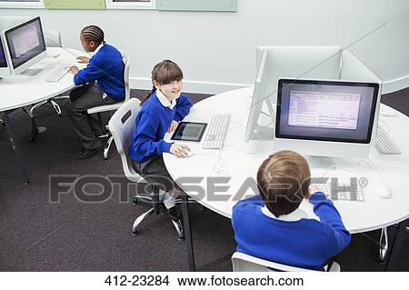 Primary school children working with computers View Large Photo Image Picture - Primary school children working with computers. Fotosearch