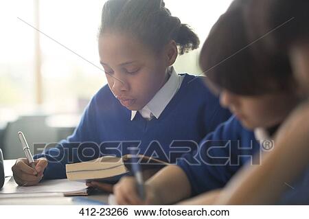 Primary school children writing in classroom View Large Photo Image Stock Photograph - Primary school children writing in classroom. Fotosearch