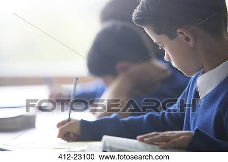Schoolboys writing at desk in classroom View Large Photo Image Stock Image - Schoolboys writing at desk in classroom. Fotosearch