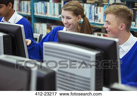 Smiling students working with computers during IT lesson View Large Photo Image Stock Photo - Smiling students working with computers during IT lesson. Fotosearch