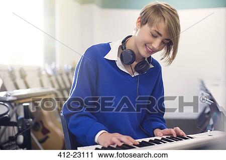 Smiling teenage student playing synthesizer View Large Photo Image Stock Image - Smiling teenage student playing synthesizer. Fotosearch