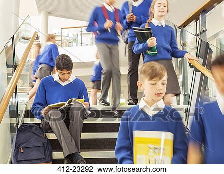 Stock Image - Students in corridor during break in high school. Fotosearch