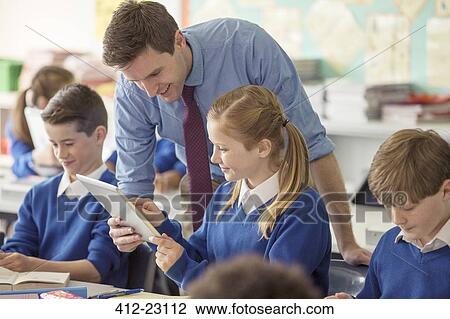 Teacher with his pupils in classroom using tablet pc View Large Photo Image Stock Image - Teacher with his pupils in classroom using tablet pc. Fotosearch