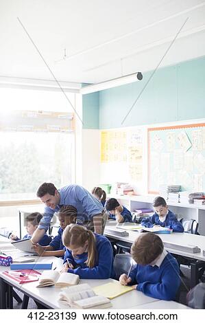 Teacher with his pupils in classroom View Large Photo Image Stock Photo - Teacher with his pupils in classroom. Fotosearch