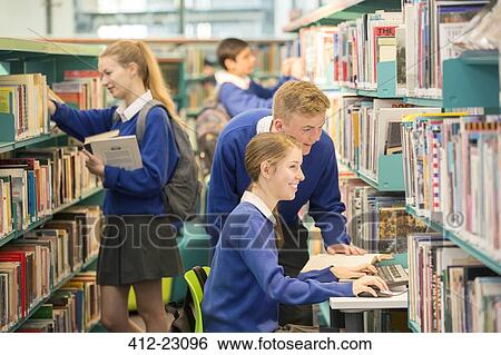 Teenage students using computer in college library View Large Photo Image Stock Photograph - Teenage students using computer in college library. Fotosearch