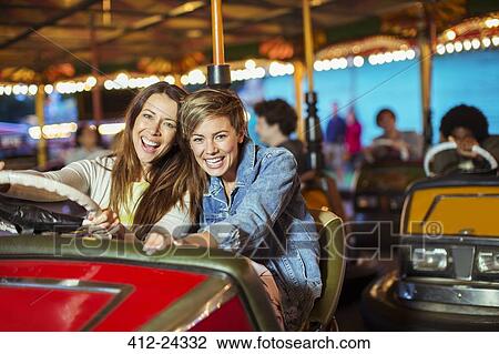 Two cheerful women on bumper car ride in amusement park View Large Photo Image Stock Image - Two cheerful women on bumper car ride in amusement park. Fotosearch