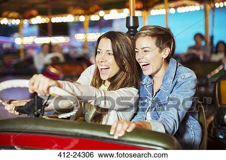 Two cheerful women on bumper car ride in amusement park View Large Photo Image Stock Photograph - Two cheerful women on bumper car ride in amusement park. Fotosearch
