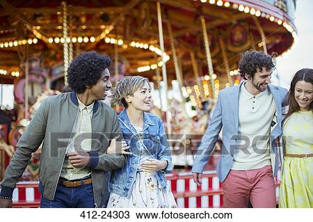 Two couples walking in amusement park and laughing View Large Photo Image Stock Image - Two couples walking in amusement park and laughing. Fotosearch