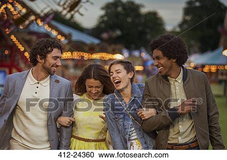 Two couples walking in amusement park and laughing at dusk View Large Photo Image Stock Image - Two couples walking in amusement park and laughing at dusk. Fotosearch