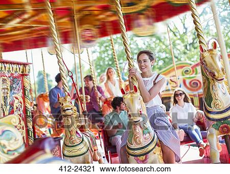 Woman sitting on horse on carousel in amusement park View Large Photo Image Stock Image - Woman sitting on horse on carousel in amusement park. Fotosearch