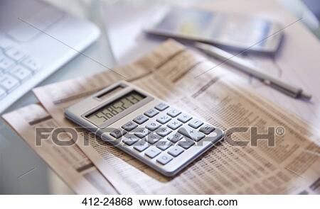 Stock Photo - "Calculator, close up, newspaper and pen on desk". Fotosearch