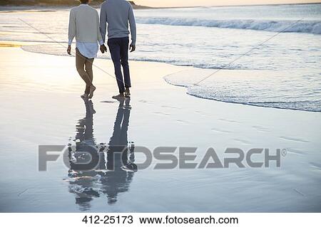 Couple holding hands and walking on beach View Large Photo Image Stock Image - Couple holding hands and walking on beach. Fotosearch