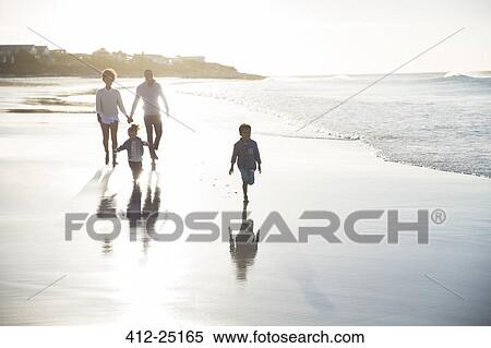 Family walking on beach at sunset View Large Photo Image Stock Photography - Family walking on beach at sunset. Fotosearch