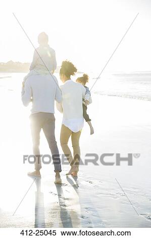 Family walking on beach in sunlight View Large Photo Image Stock Photography - Family walking on beach in sunlight. Fotosearch