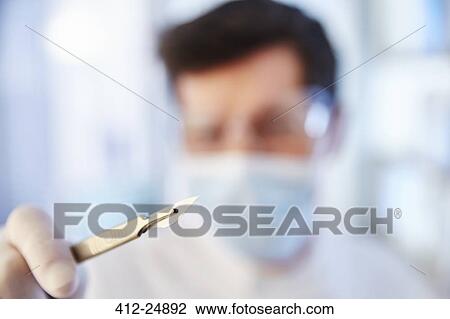 Focus on man's hand holding scalpel View Large Photo Image Stock Image - Focus on man's hand holding scalpel. Fotosearch