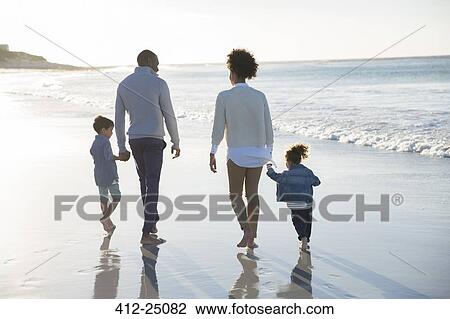 Stock Image - Happy family having fun on beach. Fotosearch