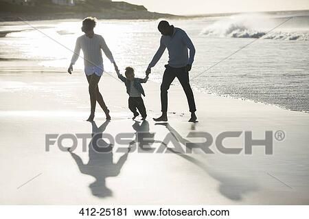 Stock Image - Happy family having fun on beach. Fotosearch