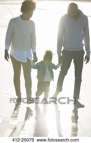Stock Photo - Happy family having fun on beach. Fotosearch