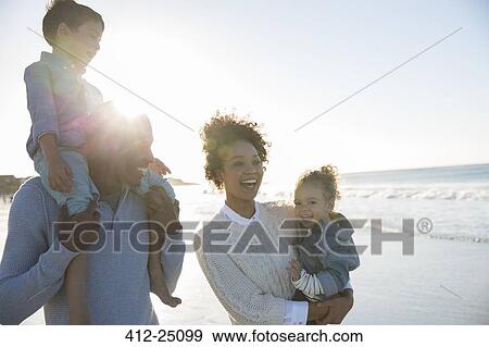 Stock Photo - Happy family having fun on beach. Fotosearch