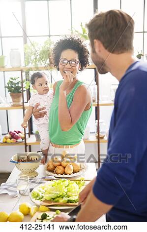Happy family preparing meal in domestic kitchen View Large Photo Image Stock Image - Happy family preparing meal in domestic kitchen. Fotosearch