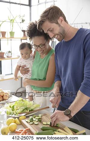 Stock Photography - Happy family preparing meal in domestic kitchen. Fotosearch