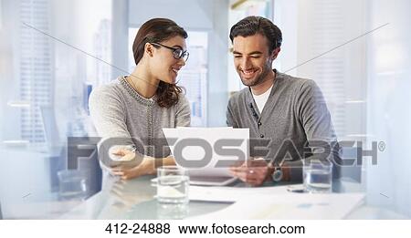 Stock Photo - Man and woman working together in office. Fotosearch