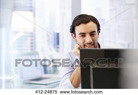 Stock Photography - Man using computer in office. Fotosearch