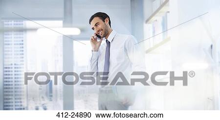 Stock Image - Man using smartphone in office. Fotosearch