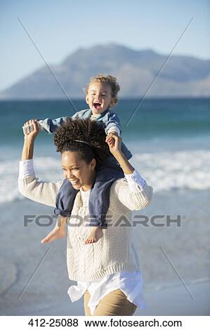 Stock Photo - Mother and daughter playing on beach. Fotosearch