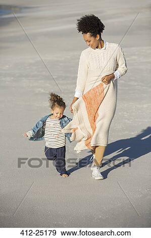 Stock Photo - Mother and daughter walking on beach. Fotosearch