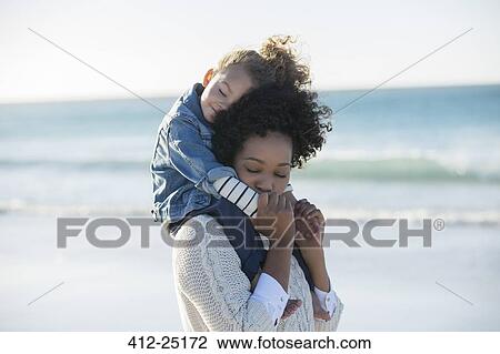 Mother carrying daughter on her shoulders on beach View Large Photo Image Stock Image - Mother carrying daughter on her shoulders on beach. Fotosearch