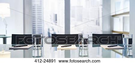 "Part of modern conference room with table chairs, pens and glasses with water" View Large Photo Image Stock Image - "Part of modern conference room with table chairs, pens and glasses with water". Fotosearch