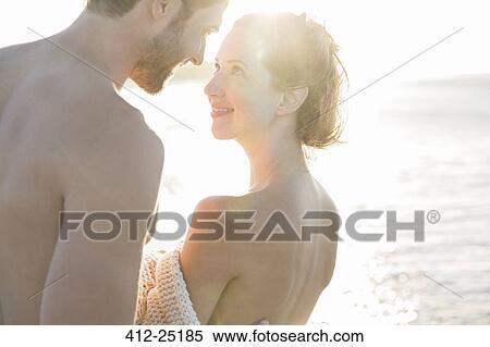 Stock Photography - Portrait of smiling young couple in sunlight. Fotosearch
