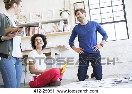 Portrait of three young people sitting on floor and working together View Large Photo Image Stock Image - Portrait of three young people sitting on floor and working together. Fotosearch