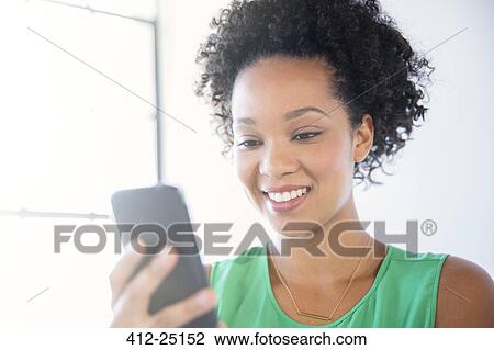 Portrait of woman with black curly hair holding mobile phone View Large Photo Image Stock Image - Portrait of woman with black curly hair holding mobile phone. Fotosearch