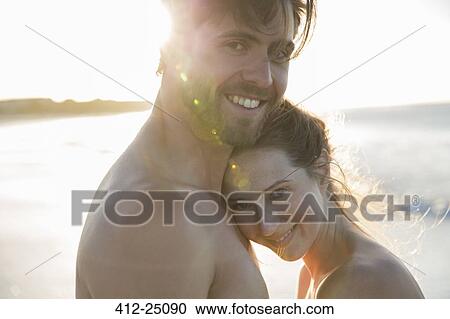 Portrait of young couple embracing on beach View Large Photo Image Stock Image - Portrait of young couple embracing on beach. Fotosearch