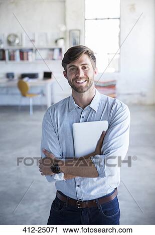 Portrait of young man standing in studio with digital tablet View Large Photo Image Stock Image - Portrait of young man standing in studio with digital tablet. Fotosearch